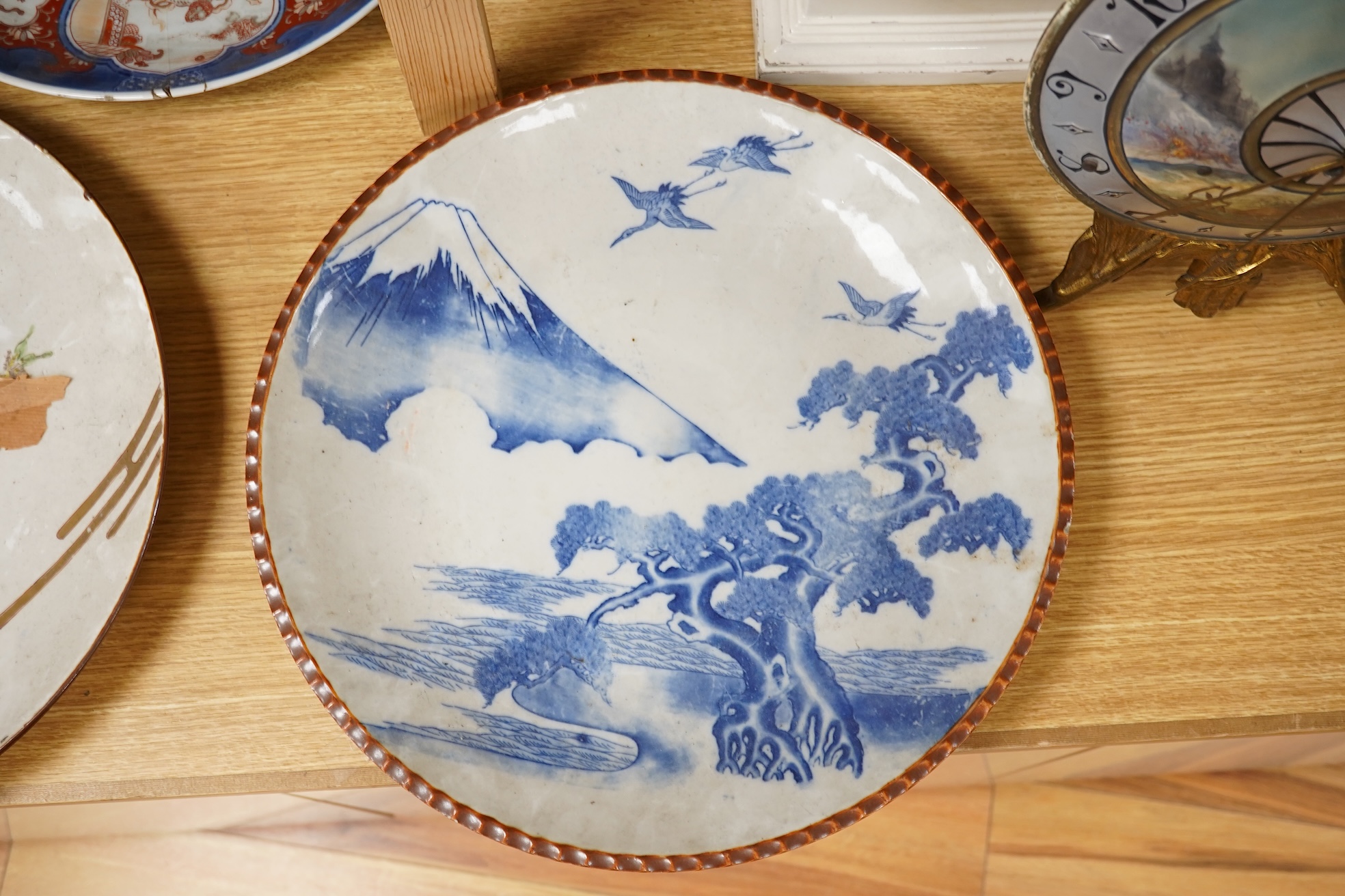 Three large Japanese dishes or chargers to include an Imari pattern example and one depicting Mount Fuji, largest 40cm in diameter